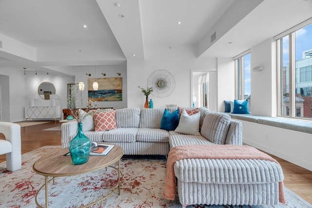 living room with baseboards, wood finished floors, visible vents, and recessed lighting