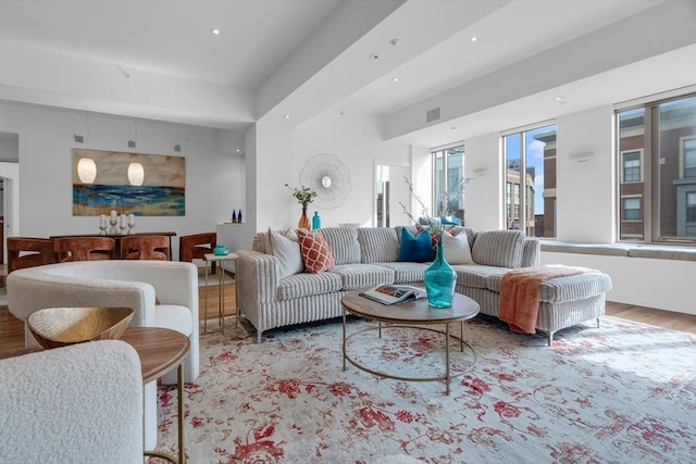 living room with recessed lighting, visible vents, and wood finished floors