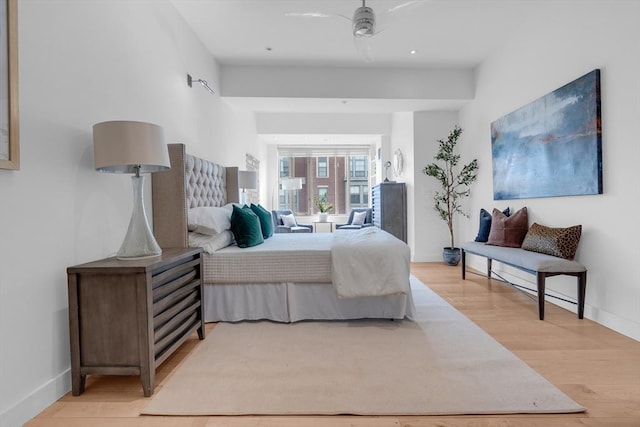 bedroom featuring light wood finished floors and baseboards