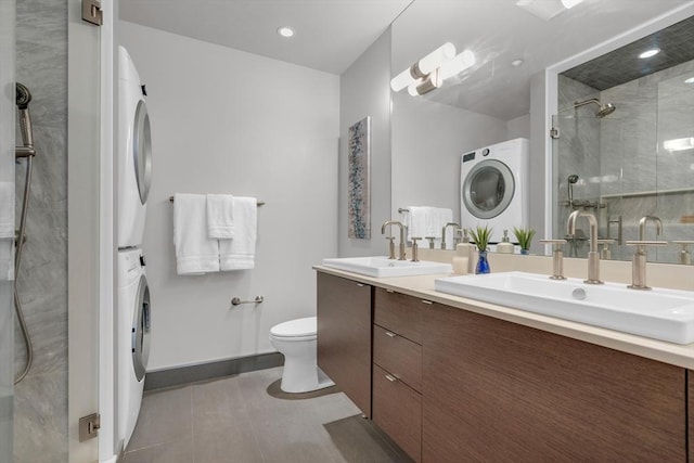 bathroom with stacked washer and dryer, a stall shower, tile patterned flooring, and a sink