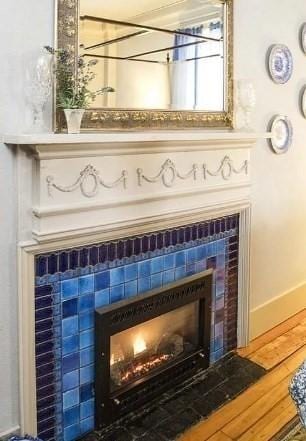 room details featuring wood finished floors, a tile fireplace, and baseboards