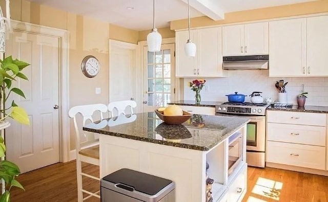 kitchen with stainless steel gas stove, under cabinet range hood, white cabinets, and light wood-style floors