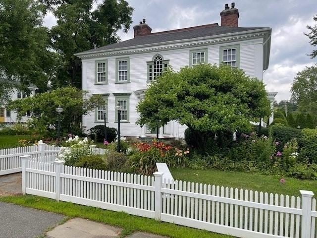 view of front of property with a fenced front yard and a chimney