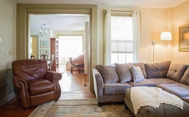 living room with wood finished floors and a notable chandelier