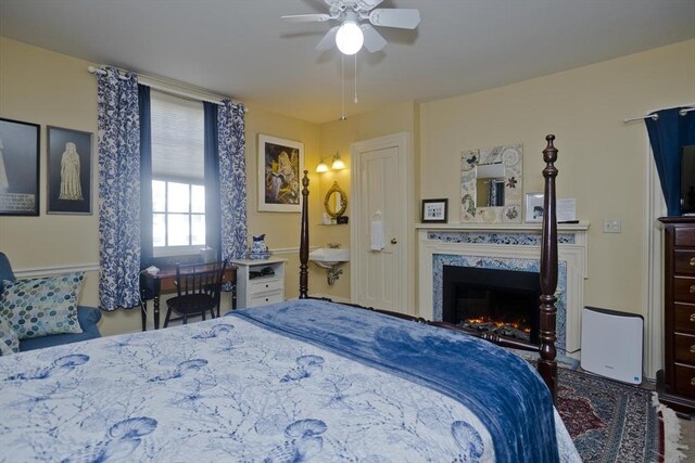 bedroom featuring a fireplace and ceiling fan