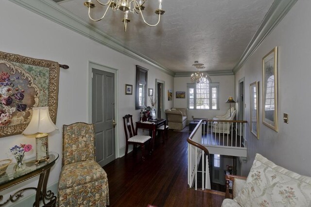 living area with a textured ceiling, an inviting chandelier, wood finished floors, and ornamental molding