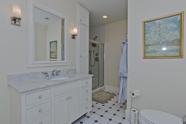 bathroom with tile patterned floors, toilet, a stall shower, and vanity
