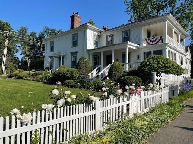 view of front of home with a chimney, a front yard, and a fenced front yard