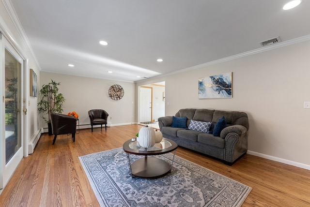 living room with light hardwood / wood-style floors, baseboard heating, and crown molding