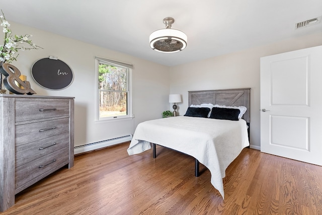 bedroom featuring hardwood / wood-style floors and a baseboard radiator