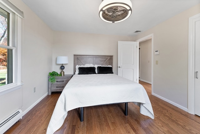 bedroom with wood-type flooring and a baseboard radiator