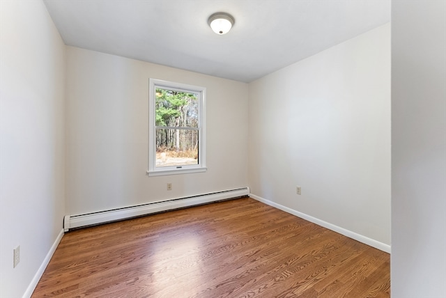 empty room with a baseboard radiator and hardwood / wood-style flooring