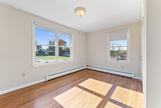 empty room with baseboard heating and light wood-type flooring