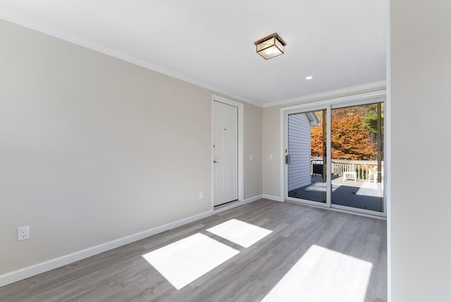 empty room with ornamental molding and light hardwood / wood-style flooring