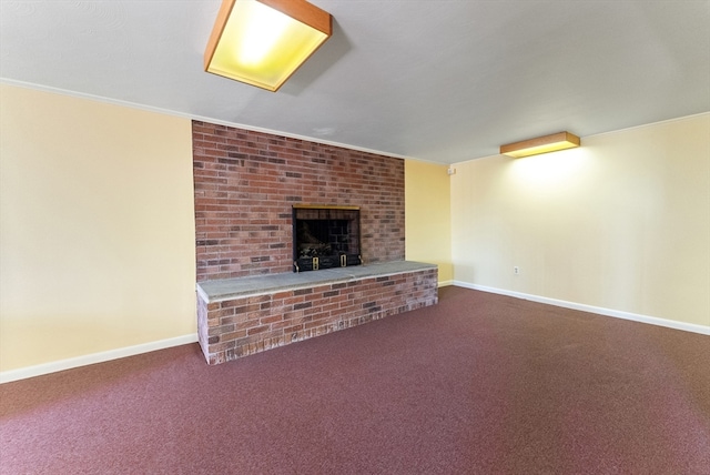 unfurnished living room with a fireplace, crown molding, and carpet