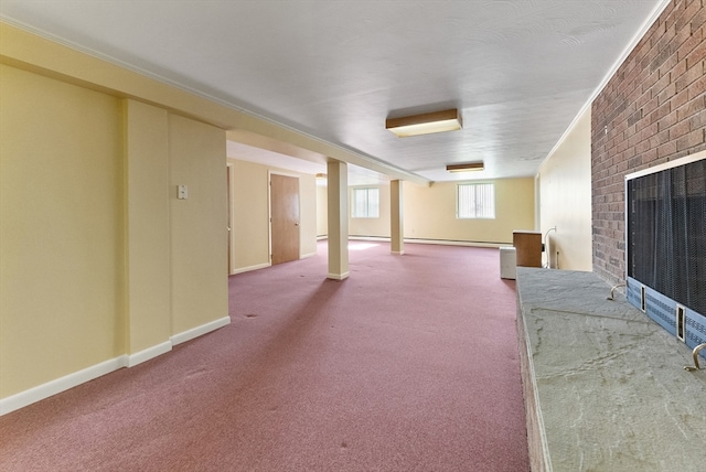 basement featuring ornamental molding, carpet floors, a brick fireplace, a baseboard heating unit, and brick wall