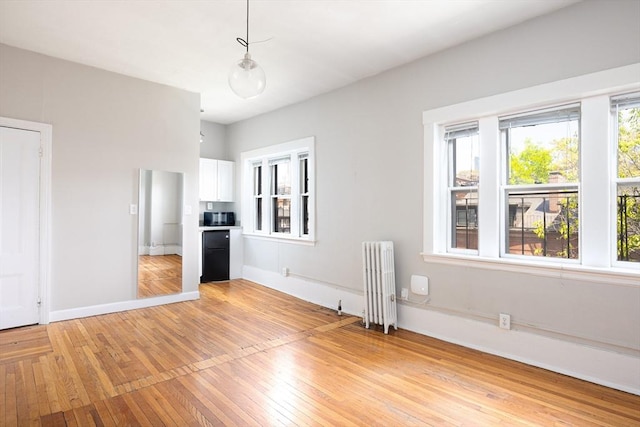 120 Charles St, Boston, MA 02114 - unfurnished living room featuring radiator heating unit, light wood finished floors, and baseboards