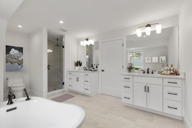 full bath with a stall shower, two vanities, and a sink