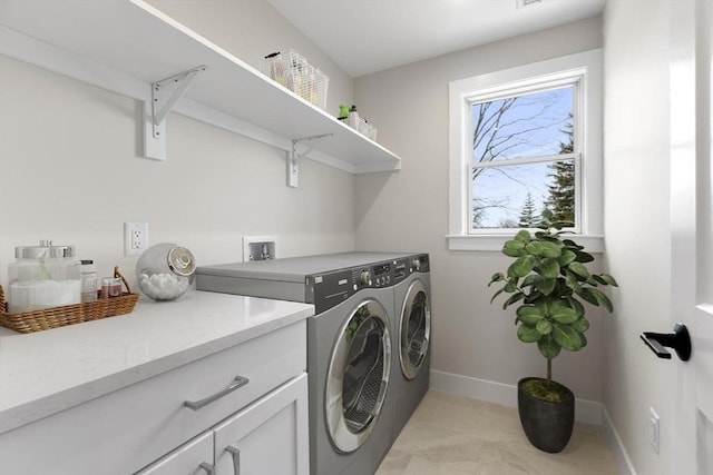 laundry room featuring cabinet space, baseboards, and washing machine and dryer