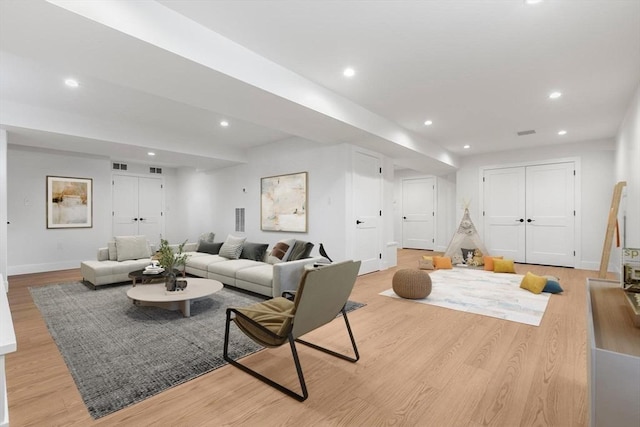 living area with recessed lighting, light wood-style flooring, visible vents, and baseboards