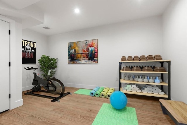 exercise room with visible vents, baseboards, and wood finished floors