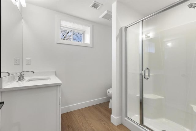 bathroom featuring visible vents, a shower stall, toilet, and wood finished floors