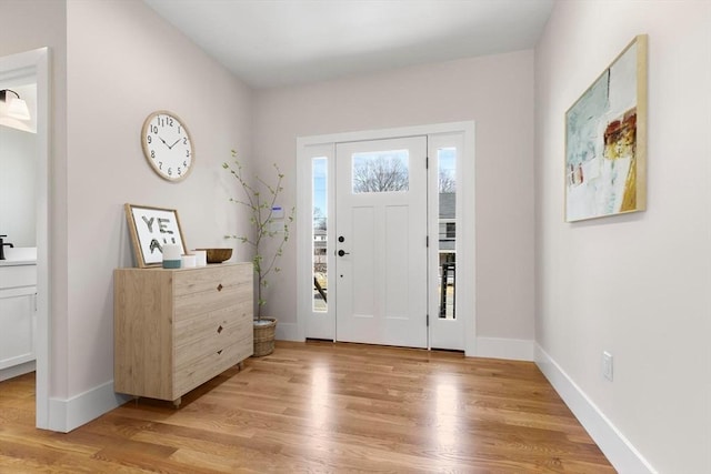 foyer featuring light wood-type flooring and baseboards