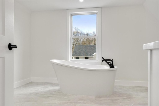 full bath featuring a soaking tub, recessed lighting, and baseboards