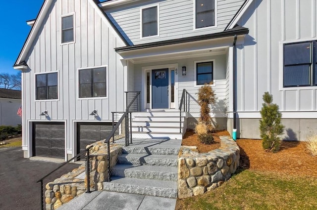 modern inspired farmhouse with a garage, board and batten siding, and driveway