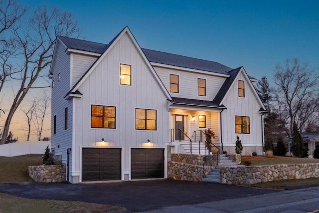 modern farmhouse featuring board and batten siding, an attached garage, and driveway