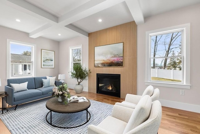 living room featuring wood finished floors, baseboards, beam ceiling, recessed lighting, and a large fireplace