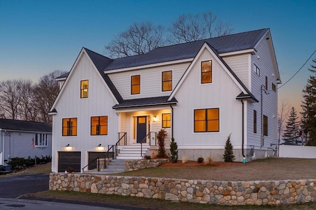 modern farmhouse with board and batten siding, an attached garage, driveway, and roof with shingles