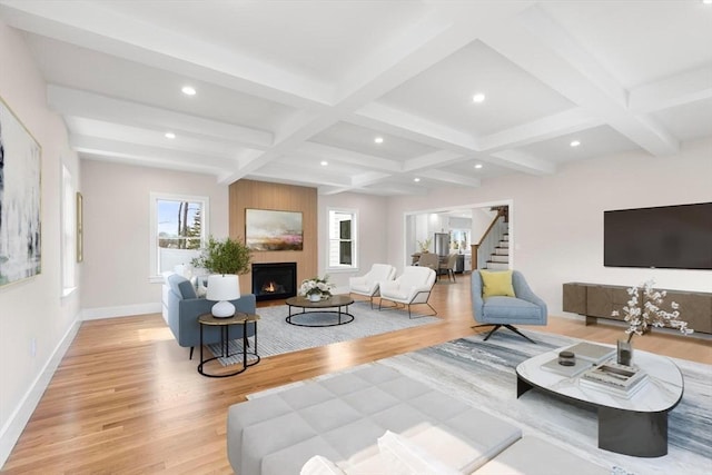 living room with light wood-type flooring, beam ceiling, coffered ceiling, and stairway