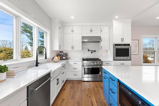 kitchen with a sink, tasteful backsplash, appliances with stainless steel finishes, and white cabinets