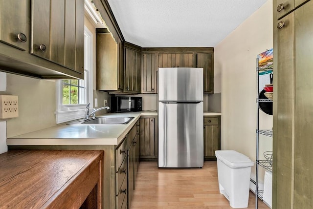25 Pheasant Cove Cir, Yarmouth, MA 02675 - kitchen with freestanding refrigerator, black microwave, light wood finished floors, light countertops, and dark brown cabinets