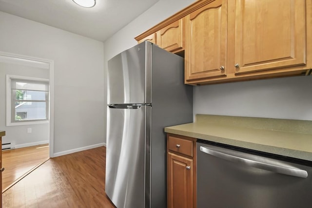 192 Pleasant St Unit 3, Leominster, MA 01453 - kitchen with appliances with stainless steel finishes, light wood-type flooring, baseboards, a baseboard radiator, and light countertops