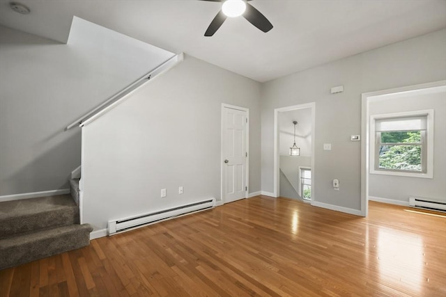 192 Pleasant St Unit 3, Leominster, MA 01453 - unfurnished living room featuring a baseboard radiator, wood finished floors, ceiling fan, stairway, and baseboards