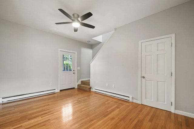 192 Pleasant St Unit 3, Leominster, MA 01453 - empty room with a baseboard heating unit, stairway, ceiling fan, and light wood finished floors