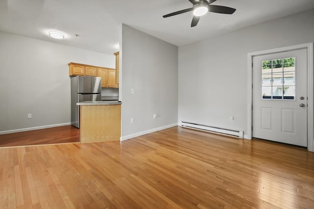 192 Pleasant St Unit 3, Leominster, MA 01453 - unfurnished living room with a baseboard heating unit, ceiling fan, light wood finished floors, and baseboards