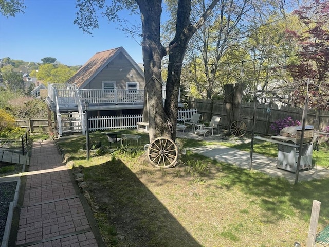 view of yard with a deck, fence, stairs, and a patio area