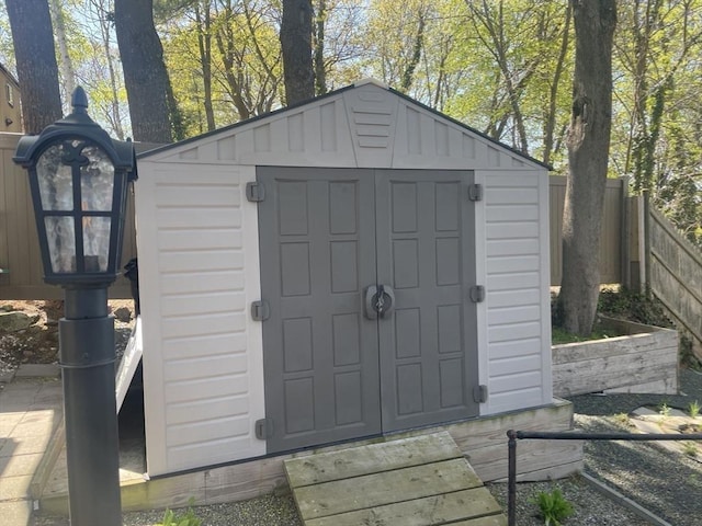 view of shed featuring fence