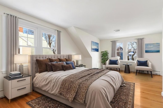 bedroom featuring light hardwood / wood-style floors and multiple windows