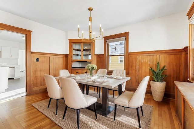 dining area with an inviting chandelier and light hardwood / wood-style flooring