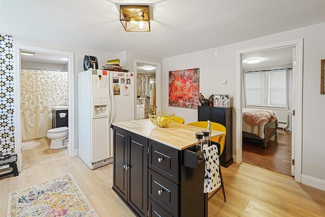 22 Tampa St, Worcester, MA 01604 - kitchen with white refrigerator with ice dispenser, dark cabinetry, light wood-type flooring, and a center island