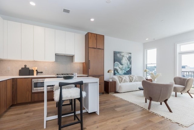 kitchen with brown cabinetry, light countertops, white cabinetry, and modern cabinets