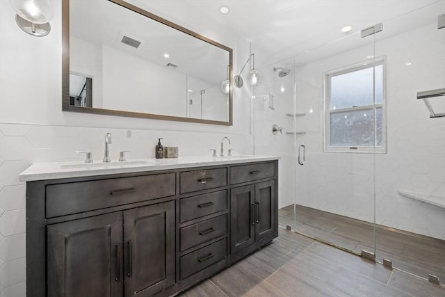9 Bond St, Boston, MA 02118 - full bath featuring a shower stall, double vanity, tile walls, and wood finished floors