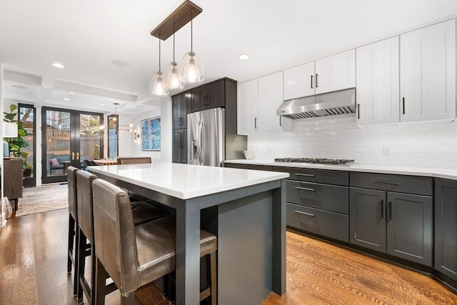 9 Bond St, Boston, MA 02118 - kitchen with stainless steel appliances, under cabinet range hood, decorative backsplash, light countertops, and recessed lighting