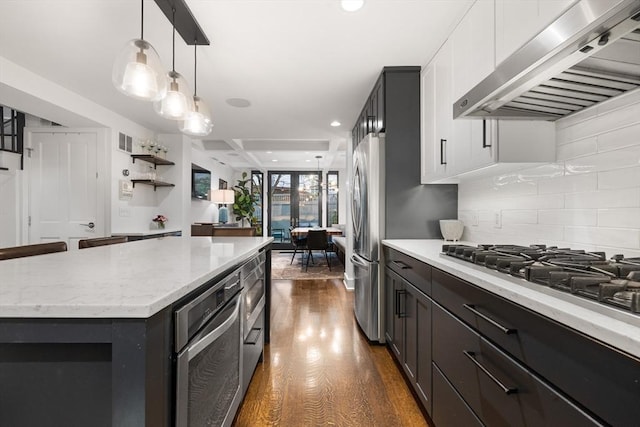 9 Bond St, Boston, MA 02118 - kitchen with range hood, dark wood-style floors, tasteful backsplash, appliances with stainless steel finishes, and recessed lighting