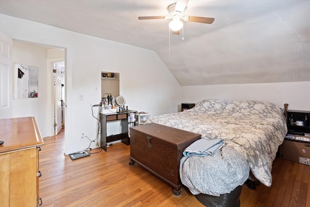 bedroom featuring ceiling fan, light wood-type flooring, and lofted ceiling