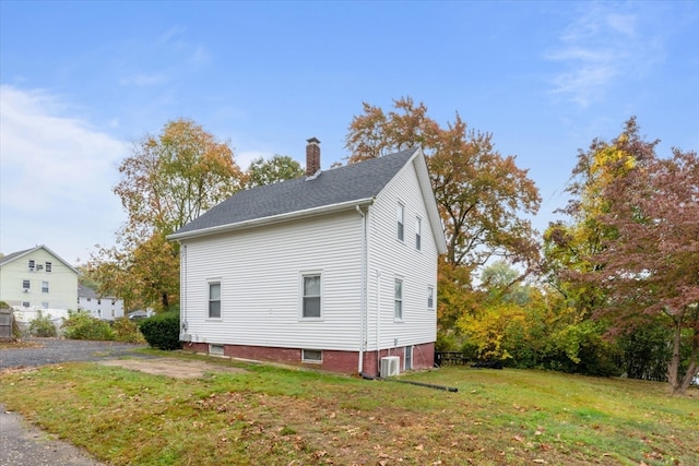 view of home's exterior featuring central AC unit and a yard